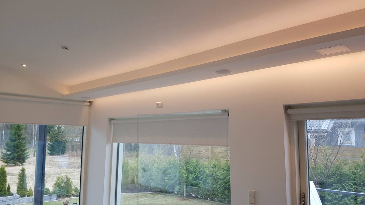 Lumière indirecte dans le salon dans deux directions. Une liste de leds dirigée vers le bas entre le plafond et le mur et l'autre dirigée vers le haut et vers l'avant depuis le dessus de l'étagère descendante. Ledstore.fi